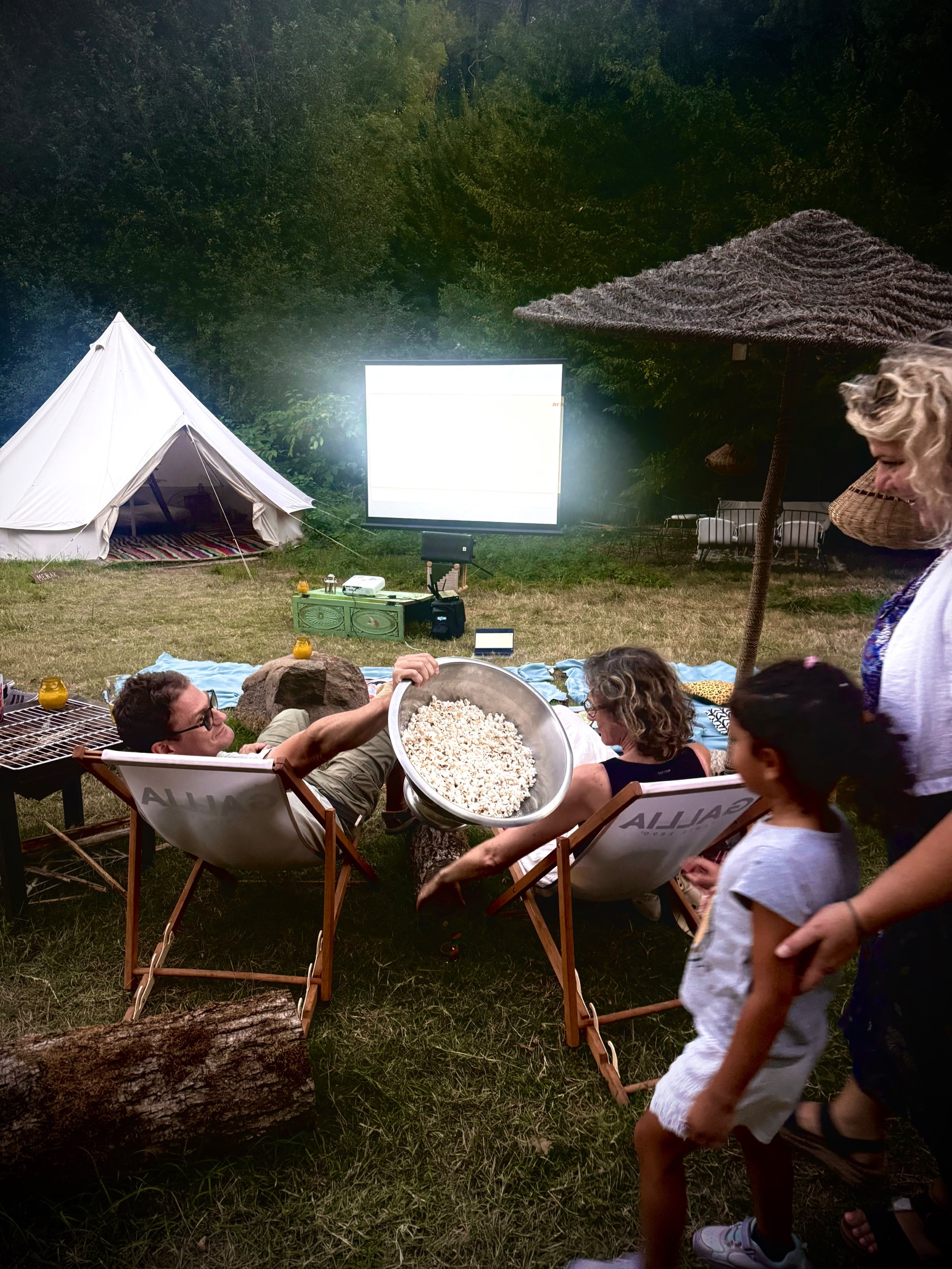 Des invités partagent du pop-corn devant le cinéma de plein air du Kârma