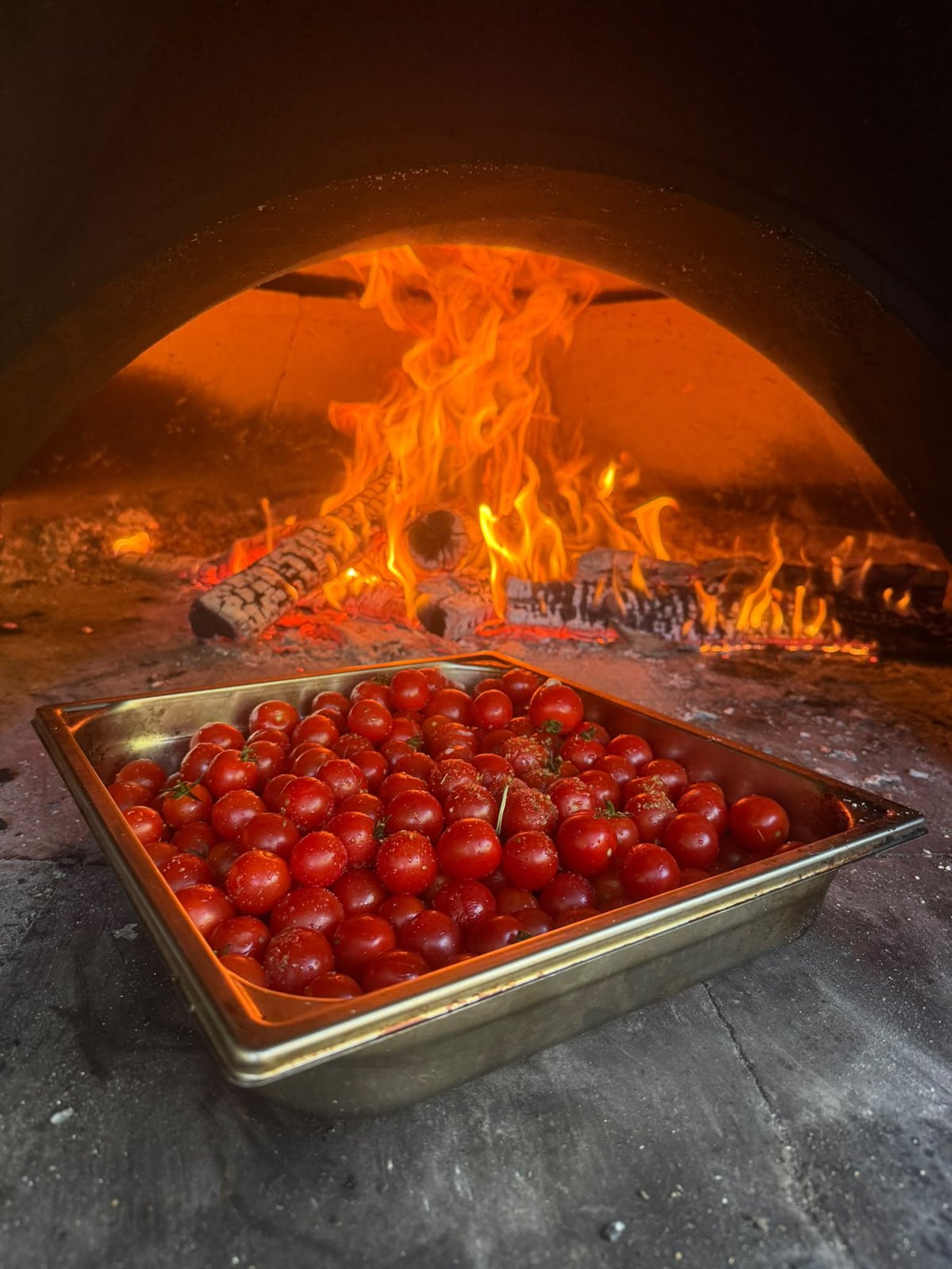 Des tomates cuisinées dans un four au feu de bois