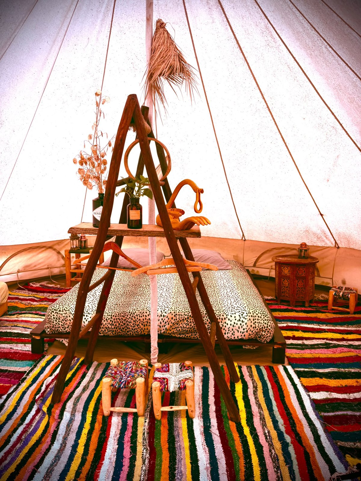 Un lit et des tapis colorés dans une chambre sous toile