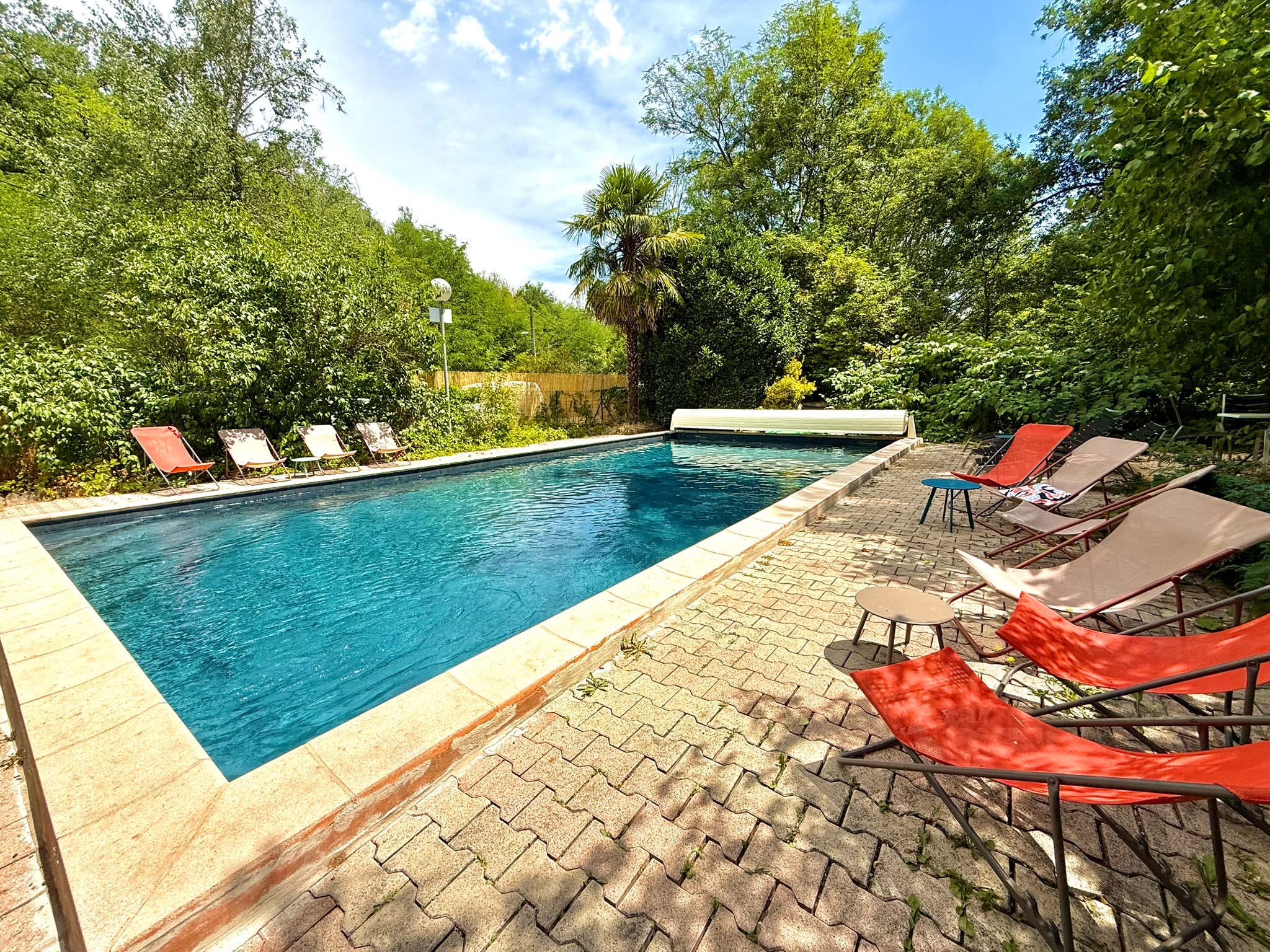 La piscine du campement de Saint-Genis-les-Ollières entourée de verdure